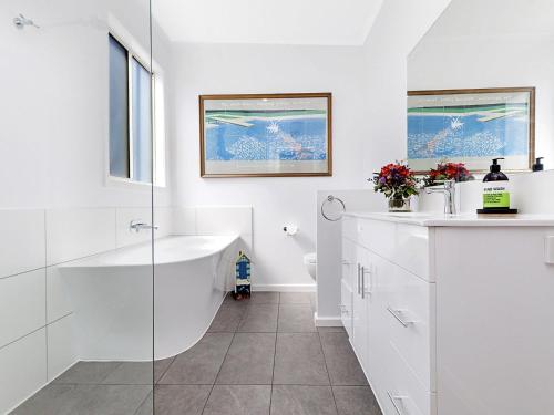 a white bathroom with a shower and a sink at Killead On East in Port Fairy