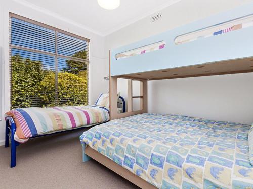 a bedroom with two bunk beds and a window at Killead On East in Port Fairy