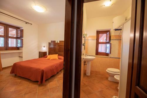 a bedroom with a bed and a bathroom with a toilet at Agriturismo Masseria Sant' Elia in Arenella