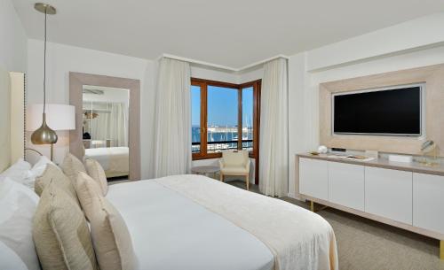a hotel room with a large bed and a television at Hotel Victoria Gran Meliá in Palma de Mallorca