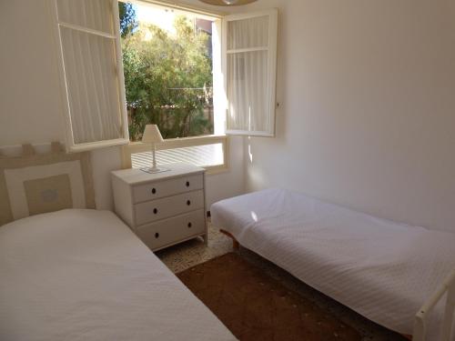 une chambre avec deux lits et une fenêtre dans l'établissement Appartement T3, RDC, 4 couchages, Front de Mer Narbonne Plage, à Narbonne-Plage