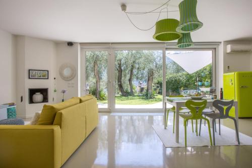 een woonkamer met een gele bank en een tafel en stoelen bij Patty's Lemonhouse in Limone sul Garda