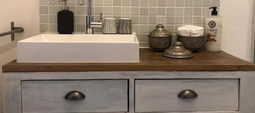 - une cuisine avec un évier blanc et un comptoir dans l'établissement Le Nid Perché - Montpellier Centre, à Montpellier