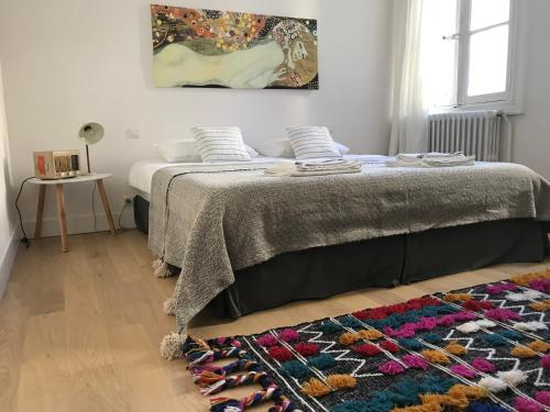 - une chambre avec un lit doté d'une couverture et d'un tapis dans l'établissement Le Nid Perché - Montpellier Centre, à Montpellier