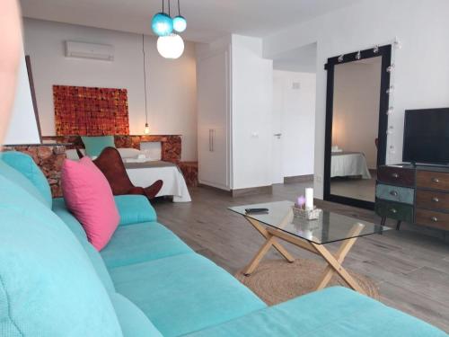 a living room with a blue couch and a television at Alojamientos 4nudos in San José