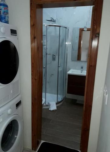 a bathroom with a shower and a washing machine at 85 Palma Living in Victoria