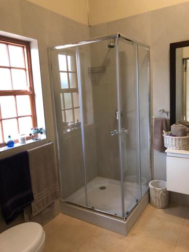 a shower stall in a bathroom with a toilet at Flavours at 34 in Gordonʼs Bay
