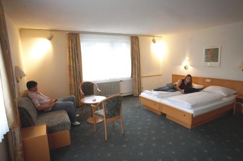 a woman laying on a bed in a hotel room at Hotel Bitburg in Bitburg