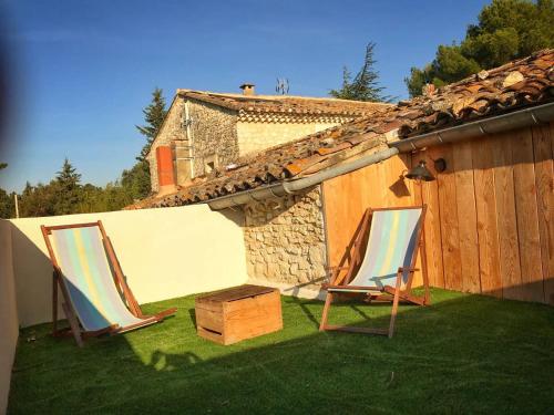 two chairs and a wooden box on a yard at Mas de L Angeos in Velleron