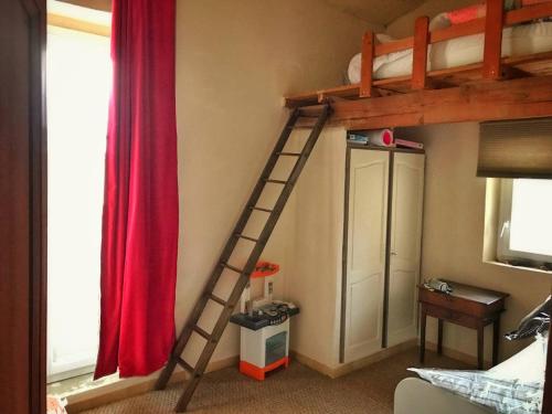a loft bed with a ladder in a bedroom at Mas de L Angeos in Velleron