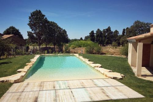 a swimming pool in the yard of a house at Mas de L Angeos in Velleron