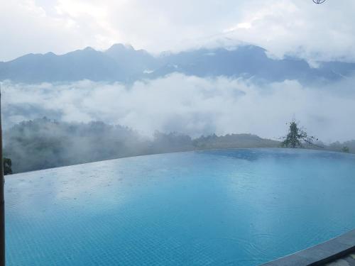 a swimming pool with a view of mountains and clouds at Sapa Clay House - Mountain Retreat in Sa Pa