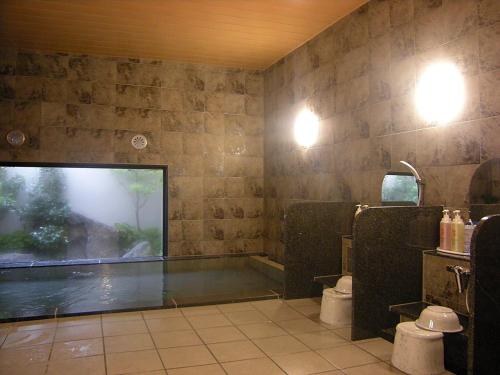 由利本荘市にあるホテルルートイン由利本荘のバスルーム(バスタブ、トイレ付)、窓が備わります。