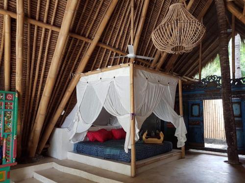 ein Schlafzimmer mit einem Himmelbett in einer Hütte in der Unterkunft Eco dive resort Alycastre in Maumere