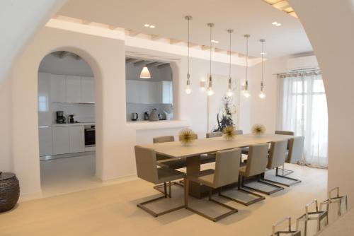 a kitchen and dining room with a table and chairs at Diles Villas & Suites Mykonos in Tourlos