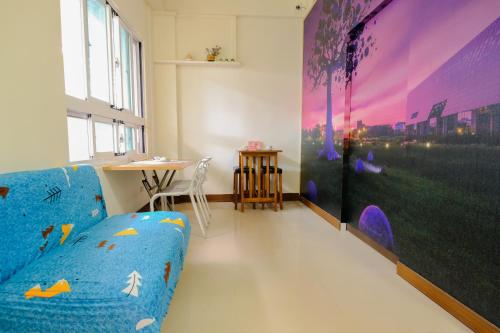 a living room with a blue couch and a table at Mei Tai Guest House in Taitung City