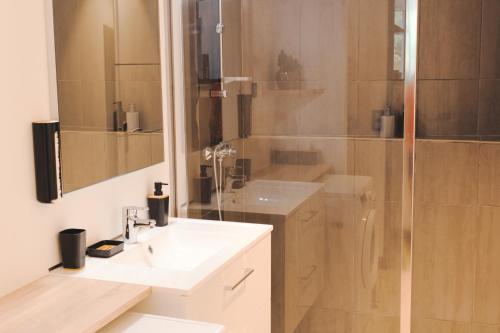 La salle de bains est pourvue d'un lavabo blanc et d'une douche. dans l'établissement Maison jardin pétanque, MEETT, Airbus, aéroport, golf, à Beauzelle