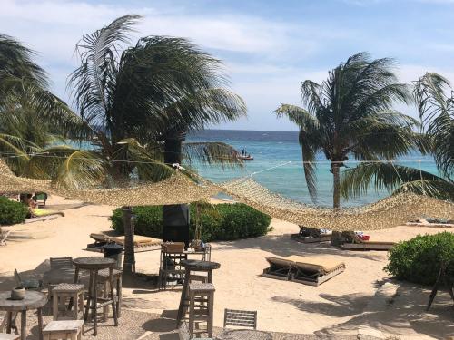 a beach with chairs and hammocks and the ocean at La Vista Luxury Apartment Jan Thiel in Jan Thiel