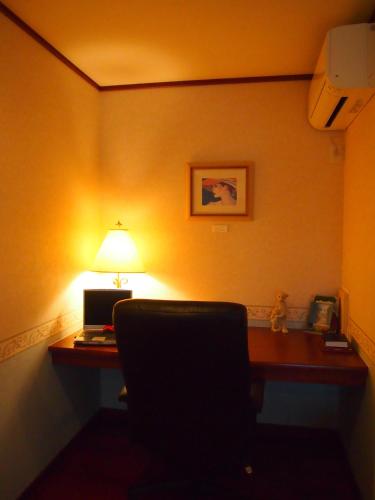 a room with a desk with a laptop and a lamp at Agri In Holiday in Hirosaki