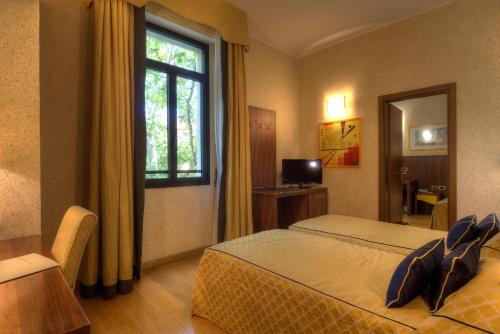 En eller flere senge i et værelse på Central Park Hotel Modena