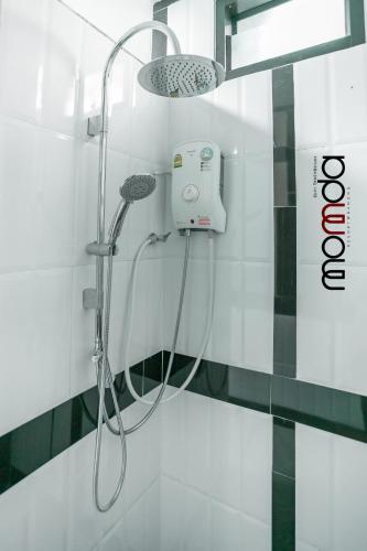 a shower with a shower head in a bathroom at Momda Resort @Ranong in Ranong