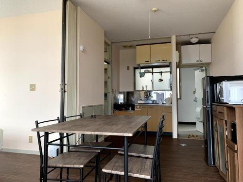a dining room and kitchen with a table and chairs at Big Stone Tsukuda 45平米 2SDbed 2For3F in Aomori