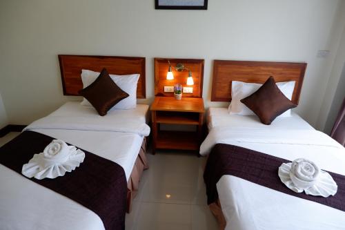a hotel room with two beds with flowers on them at Khao Sok Nature Place - SHA Certified in Khao Sok