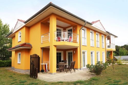 a yellow house with a patio in front of it at Fewo Ostsee Urlaub_DOHR in Ostseebad Karlshagen
