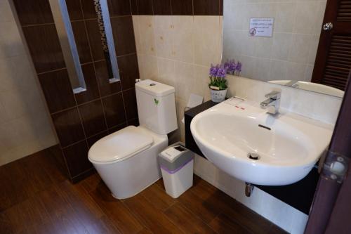 a bathroom with a white toilet and a sink at Khao Sok Nature Place - SHA Certified in Khao Sok