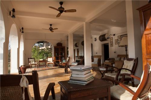 a living room with a stack of books on a table at Jim's Jungle Retreat in Rāmnagar
