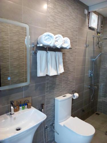 a bathroom with a toilet and a sink and a shower at J7 Villaj Resort in Trincomalee
