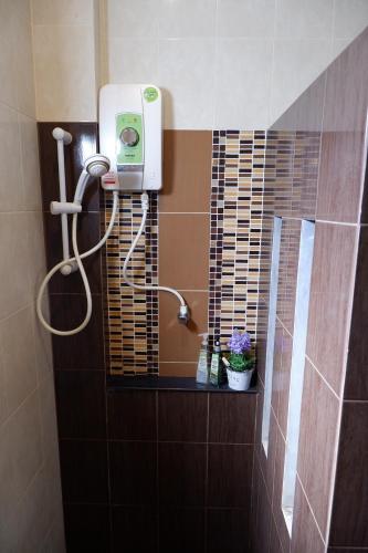 a bathroom with a shower with a blow dryer at Khao Sok Nature Place - SHA Certified in Khao Sok