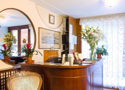 a waiting room with a reception desk and a mirror at Hotel Leonardo in Venice