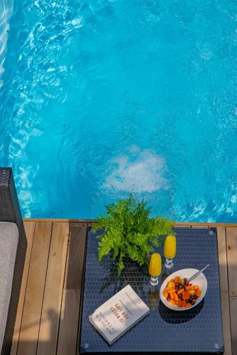 a table with a plate of food next to a swimming pool at Bay Lodge on the Beach in Mossel Bay
