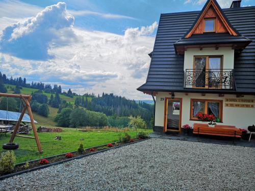 una casa con un banco delante de ella en Domek u Matusa, en Gliczarów Górny