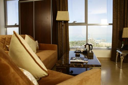 لاغونا هوتيل سويتس  في الكويت: غرفة معيشة مع أريكة وطاولة
