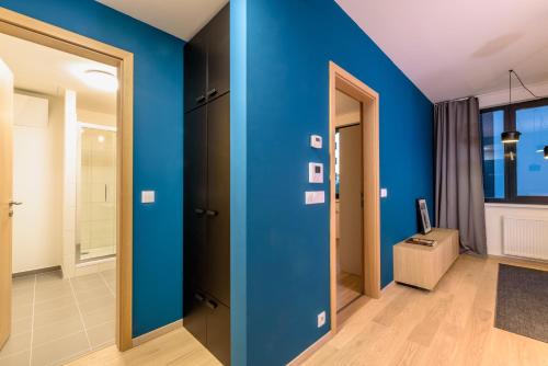 um quarto com paredes azuis e um corredor em Bratislava center, river front, private parking included em Bratislava
