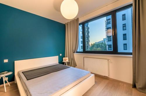 a bedroom with a bed and a large window at Bratislava center, river front, private parking included in Bratislava