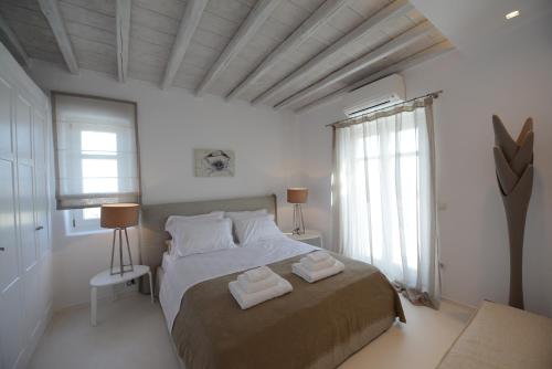 a bedroom with a bed with two towels on it at Diles Villas & Suites Mykonos in Tourlos