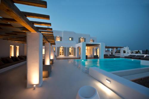 a villa with a swimming pool at night at Diles Villas & Suites Mykonos in Tourlos