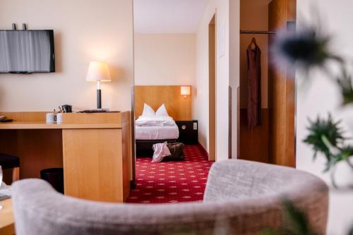 a hotel room with a bed and a desk at Hotel am Jungfernstieg in Stralsund