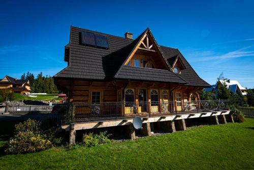 una gran casa de madera en una terraza de madera en Villa z widokiem na Giewont, en Kościelisko