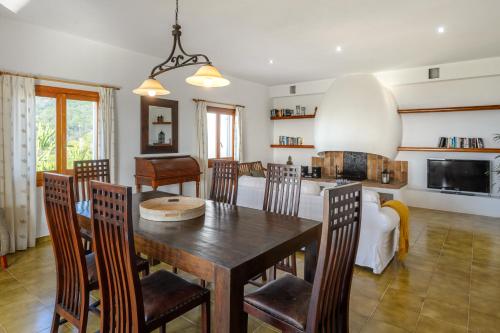 a kitchen and dining room with a wooden table and chairs at CAN COSTA Amazing view of sunset on the sea in Cala Vadella