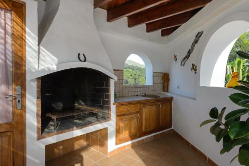 a kitchen with a fireplace and a sink at CAN COSTA Amazing view of sunset on the sea in Cala Vadella