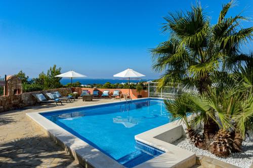a swimming pool with a palm tree next to a house at CAN COSTA Amazing view of sunset on the sea in Cala Vadella