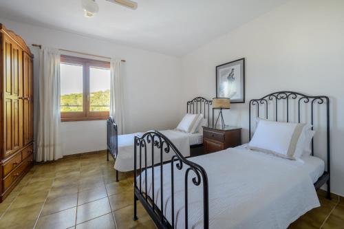 a bedroom with two beds and a window at CAN COSTA Amazing view of sunset on the sea in Cala Vadella