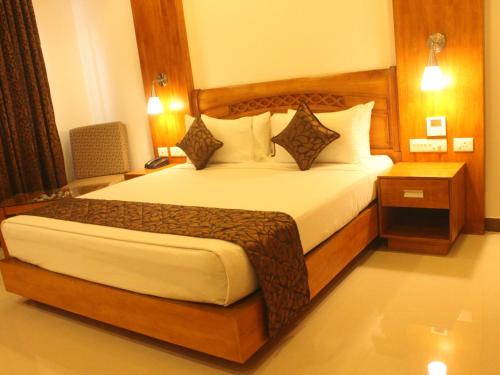 a bedroom with a large bed with white sheets and pillows at The Hotel Canoe in Kannur