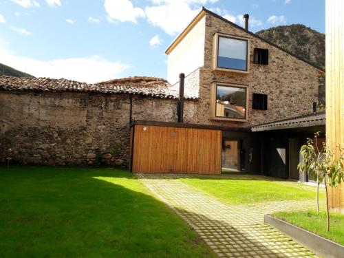 an external view of a house with a stone wall at Hotel EN in El Pont de Suert