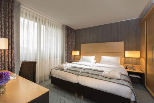 a hotel room with a large bed and a large window at Maritim Hotel Düsseldorf in Düsseldorf