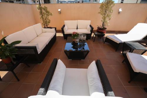 an outdoor patio with white couches and tables at Sky Suites in Beirut